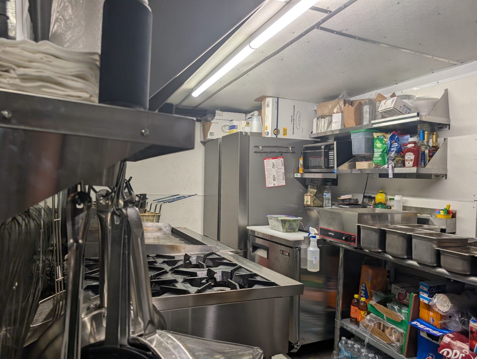 Inside the Chez Leon food truck kitchen, with the grill and prep station ready for service.